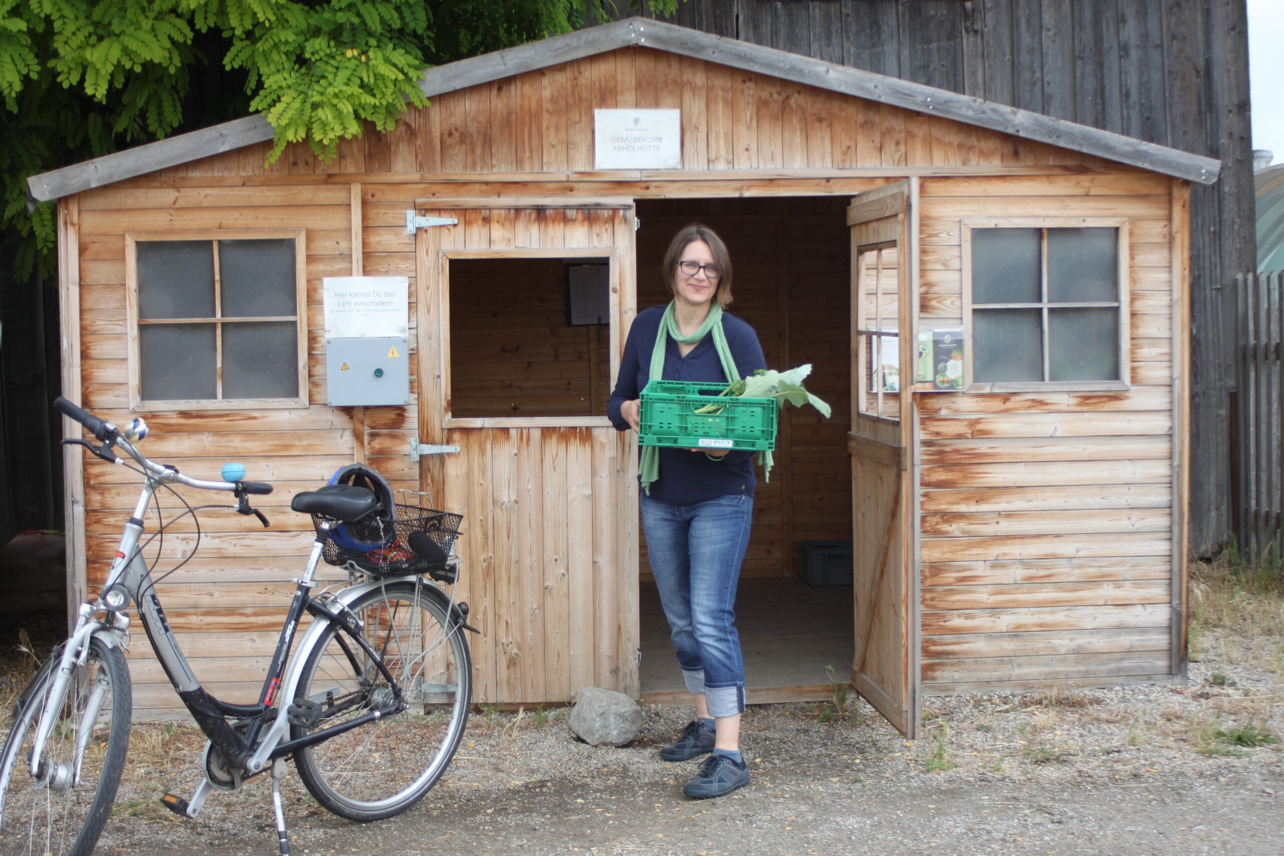 Gertraud Moser beim Abholen ihrer Gemüsekiste vom örtlichen Bio-Bauern mit dem Rad.